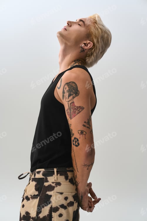 Preview: Handsome young man showcases stylish tattoos in a modern, minimalist studio setting