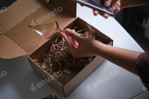 Preview: woman opens a delivery box from a store and discovers a broken glass.