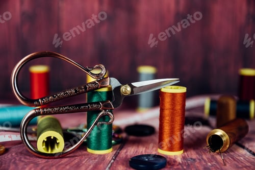 Preview: Front view of vintage sewing scissors with spools of colored threads and needles.