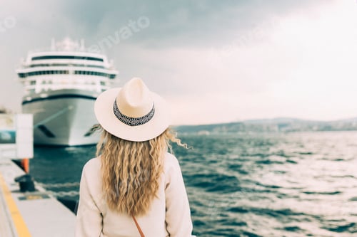 Preview: Woman tourist standing in front of big cruise liner, travel female