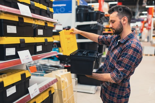Preview: a man in a construction hypermarket chooses a case for a tool