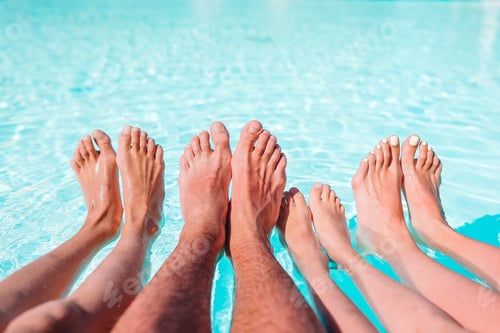 Preview: Close up of four people's legs by pool side
