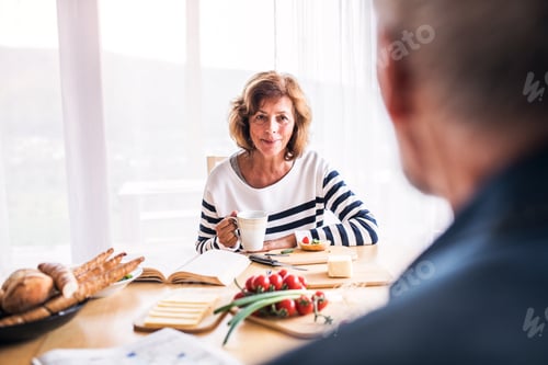 Preview: Senior couple eating breakfast at home.