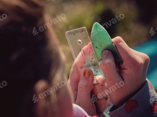 Preview: Crop preteen girl measuring piece on plastic with ruler