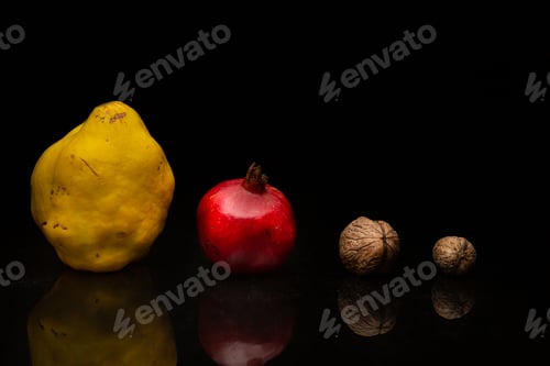 Preview: Walnuts with pomegranate and quince on black background