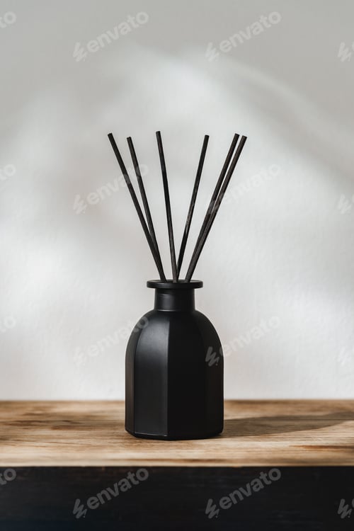 Preview: Black Reed Diffuser on a Wooden Table With Soft Light Casting Shadows