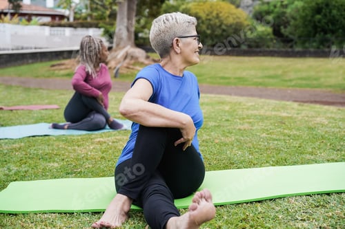 Preview: Senior people doing yoga class keeping distance at city park - Focus on right woman face