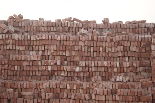 Visualização: Tijolos empilhados em um canteiro de obras na luz do início da manhã