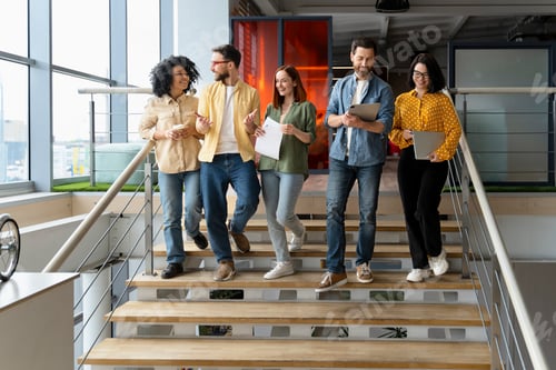 Preview: Group of successful office employees going down the stairs for a coffee break. People. Career growth