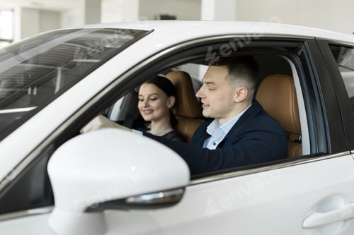 Visualização: Casal casado, marido e mulher sentados em um carro em uma concessionária de automóveis. Teste o carro antes de comprar.