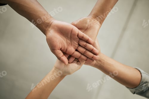 Preview: Close up of four colleagues putting hands together in the office. Creative team joining hands and s