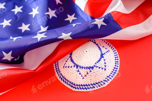 Preview: Jewish kipa under an American flag, isolated on red background