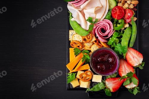 Preview: Antipasto platter cold sliced ham, salami, crackers, strawberries, vegetables and cheese platter