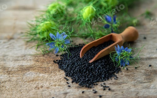 Preview: Black cumin seeds and flowers. Selective focus.