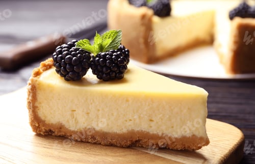 Preview: Piece of delicious cheesecake decorated with blackberries on table