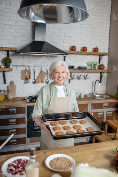 Preview: Elderly woman cooking pastry in her kitchen