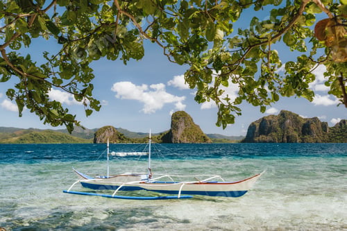 Preview: Banca boat in shallow blue water on Ipil beach of Pinagbuyutan Island, El Nido, Palawan, Philippines