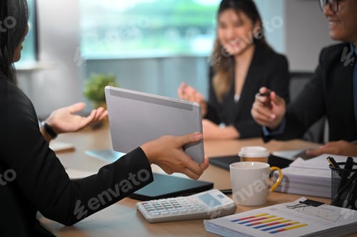 Preview: Colleagues collaborating in a modern office, discussing financial data and marketing strategies