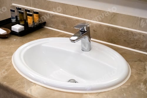 Preview: faucet for water and white sink on marble counter