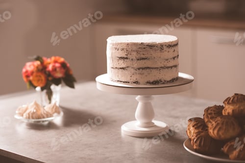 Preview: Tasty cake with cream cheese staying on kitchen table closeup. Cooking at home. Homemade.