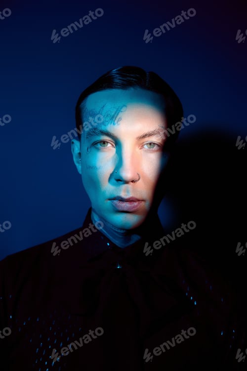 Preview: Stylish young man showcases modern fashion with striking lighting and artistic shadows