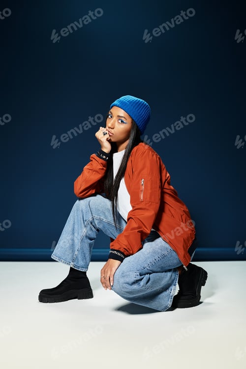 Preview: Stylish young woman poses confidently in warm autumn attire against a dark backdrop
