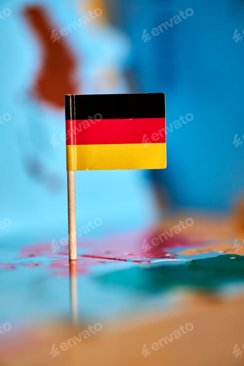 Preview: Closeup of a flag of Germany with a small stick on the map