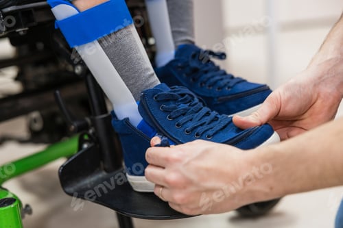 Preview: Person helping child with leg brace and special shoes