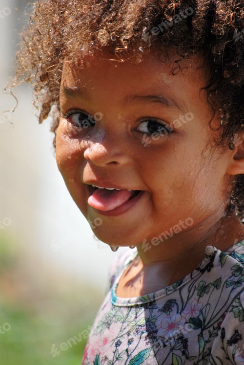 Preview: Portrait of a little girl having fun with water during a hot summerday