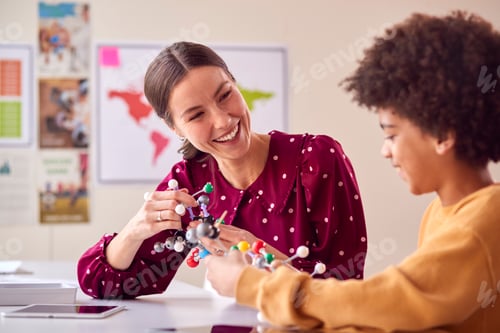 Preview: Teacher And Male Student In School Science Class Studying Molecular Model