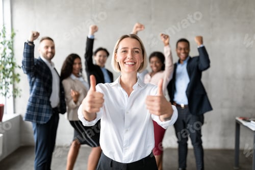 Preview: Businesswoman Gesturing Thumbs-Up Standing With Joyful Employees Team In Office