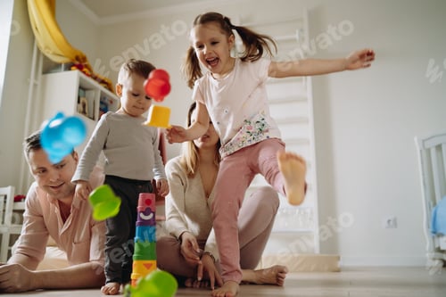 Preview: family play at home. girl breaking toy tower