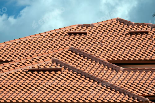 Preview: Overlapping rows of yellow ceramic roofing tiles covering residential building roof