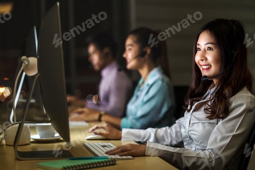Preview: Asian Female customer care service with business man smiling and working hard late