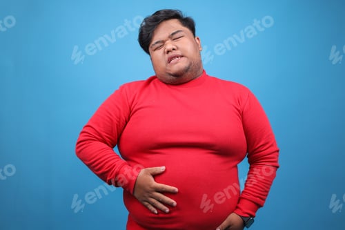 Preview: Young Fat Guy Feeling Full After Eating A Lot Over Blue Background