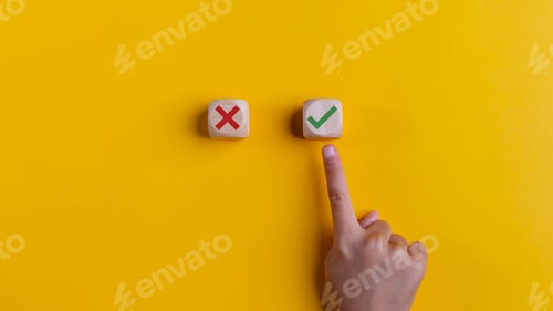 Preview: Right and wrong icons on wooden cubes with hand choosing the right icon on yellow background.
