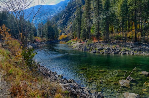 Preview: River surrounded by hills and trees in a forest in Leavenworth in autumn