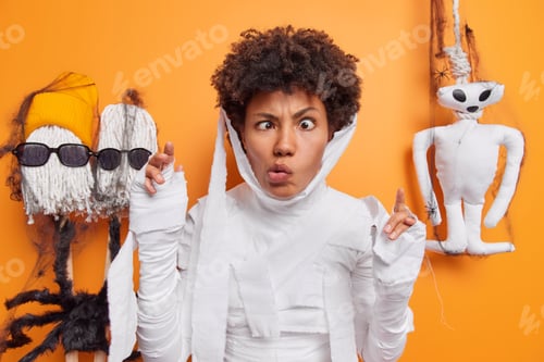 Preview: Curly haired displeased Afro American ghost crosses eyes makes angry grimace pretends being very sca