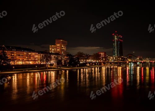 Preview: City lights reflecting on the glowing river surface at night in Frankfurt, Germany