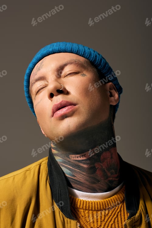 Preview: A young man with tattoos and a beanie exudes confidence in a thoughtful pose