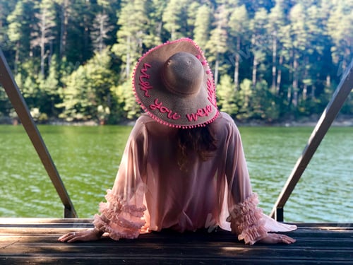 Preview: Woman Wearing Sun Hat on Dock Overlooking Lake
