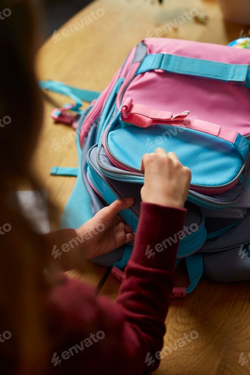 Preview: Schoolgirl put books and notes into backpack at home, pupil prepare staff for education