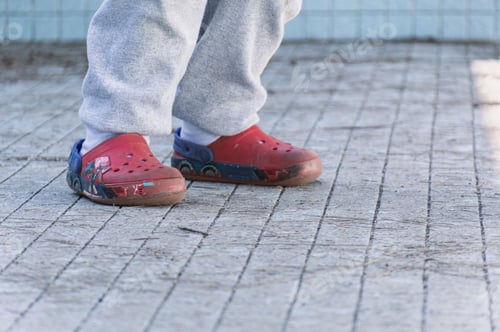 Preview: Closeup shot of a child wearing red water shoes
