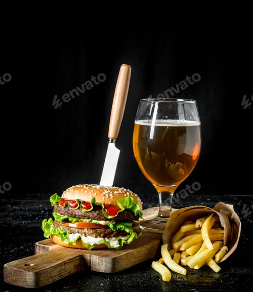 Preview: Burger with a knife,fries, beer in a glass.