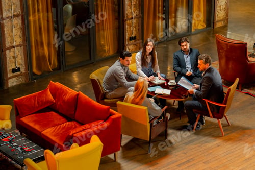 Preview: top shot in large beautiful hall office employees sitting on yellow chairs discuss a deal