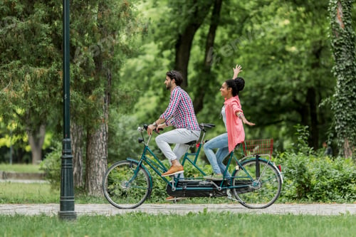 Preview: Young couple riding on the tandem bicycle