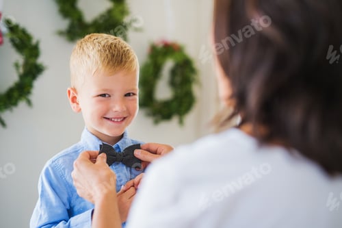Preview: A grandmother putting a bowtie on a small boy at Christmas time.
