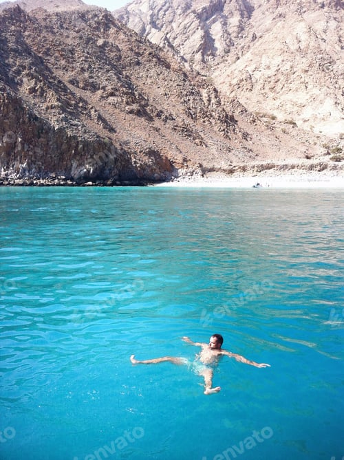 Preview: Swimming in the blue water close to the mountains