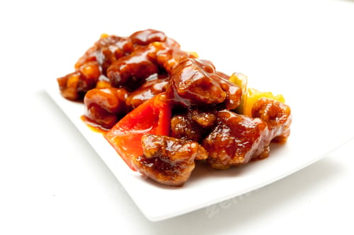 Preview: Closeup of Chinese chicken with sauce and pepper slices on a white plate isolated on a white surface