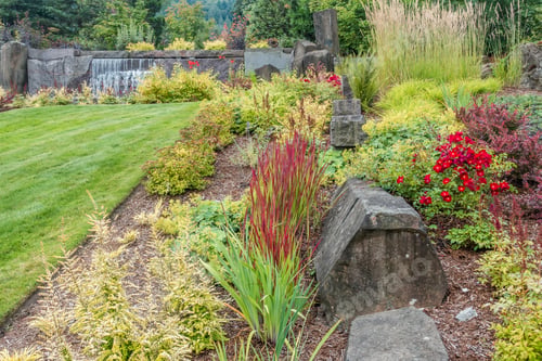 Preview: View Of A Fountain Made Up Of Rock Walls And Waterfalls. Garden In The Foreground.